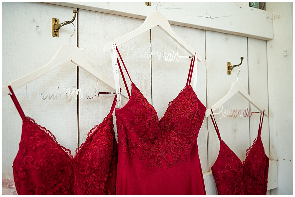 Red bridesmaid dresses hanging on personalized hangers